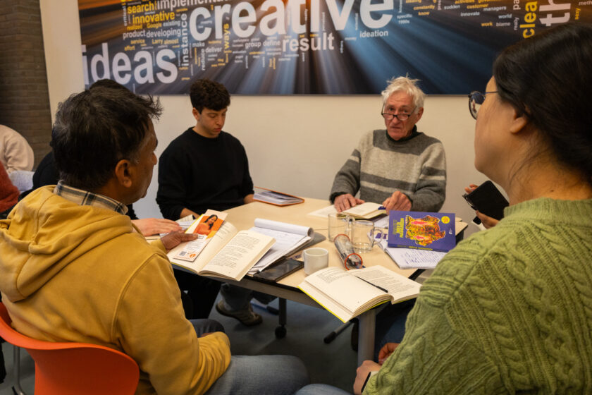 Bezoekers van bibliotheek Enschede-Haaksbergen gaan aan tafel met elkaar in gesprek over het boek Onder de Paramariboom
